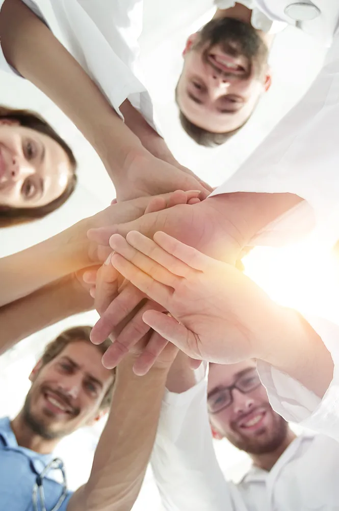 Pflegeteam legt Hände übereinander